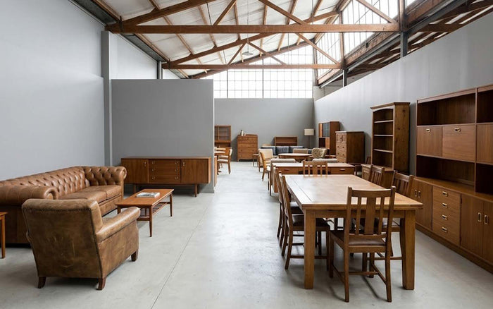 Quality second-hand furniture including leather sofas, wooden dining tables and storage cabinets in a Melbourne furniture showroom